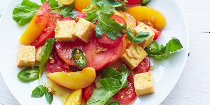 Salad with tomatoes. Spicy salad with tomato, arugula, peach and tofu