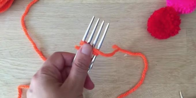 How to make a pompom: start wrapping the fork with thread