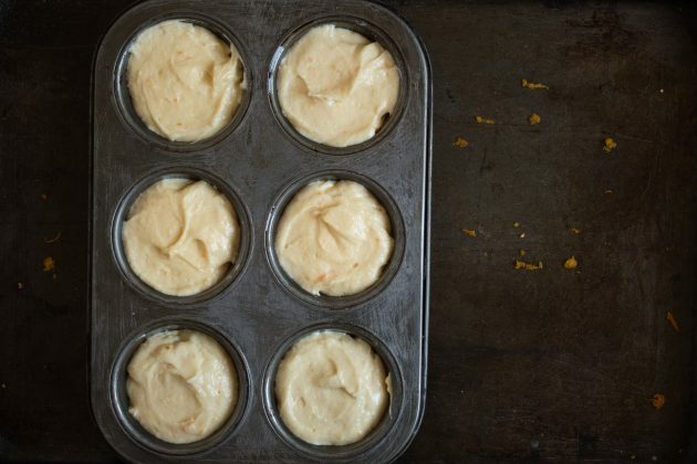 How to make tangerine muffins: distribute the dough into tins