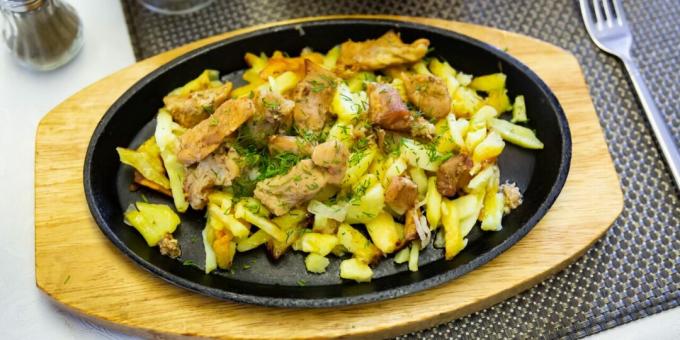 Fried potatoes with meat in a frying pan