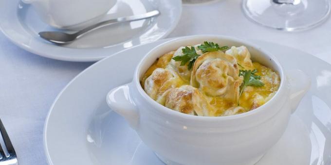 Dumplings in a pot with vegetables and cheese