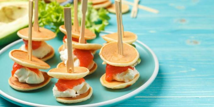 Canape of mini-pancakes with salmon and cheese