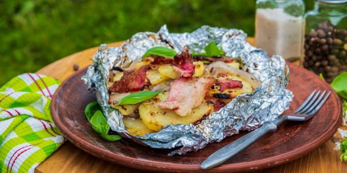 Potatoes with onions and bacon in foil on coals