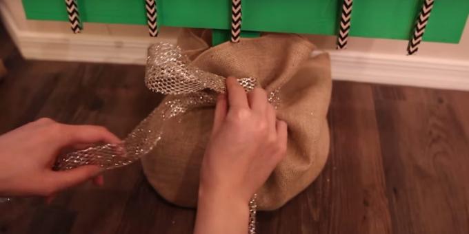 Place the Christmas tree, wrap the stand burlap and tie ribbon