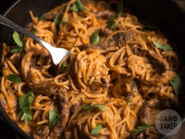 Pasta with beef in tomato-cream sauce, served sprinkled with parsley and pepper