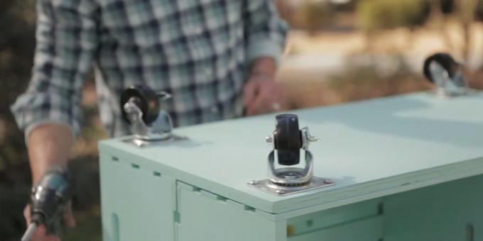 a coffee table with his hands: Attach the wheels