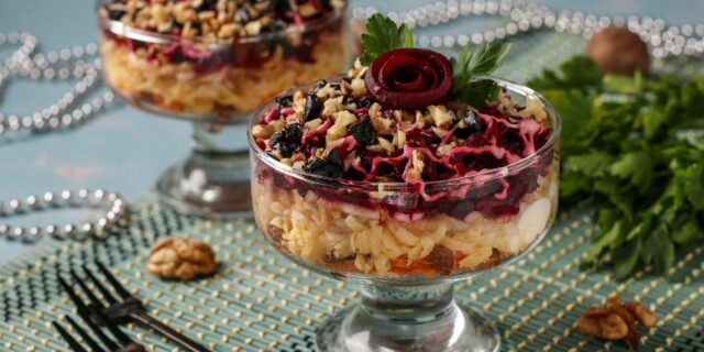 Layered salad with cheese, apples and prunes