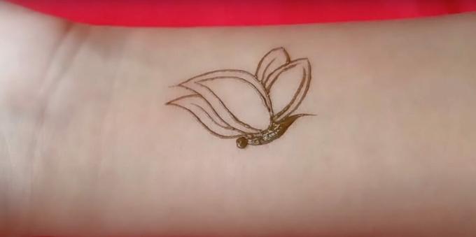 Henna butterfly drawing on the hand: depict the wings