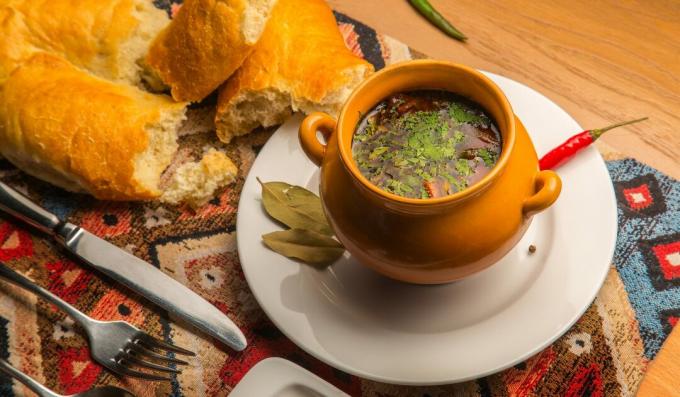 Spicy soup with beef and tomatoes in pots