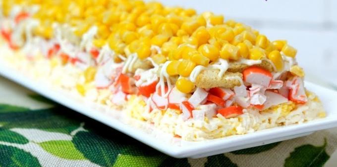 Puff salad with crackers, crab sticks, corn and melted cheese
