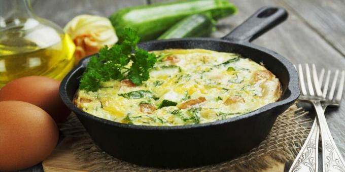 Omelet with chicken and zucchini in a frying pan