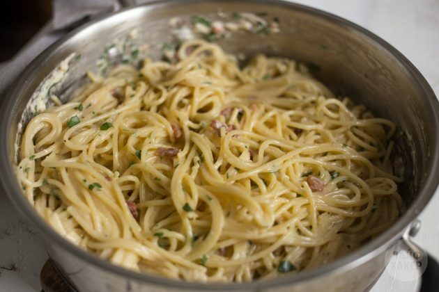 How to make carbonara pasta: add sauce, bacon and herbs to spaghetti