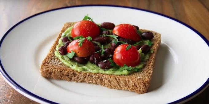 Quick breakfast: a sandwich with avocado, beans and tomato