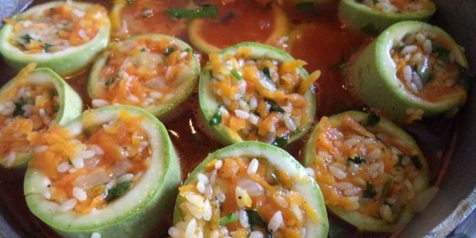 Zucchini stuffed with rice and vegetables and stewed in tomato sauce