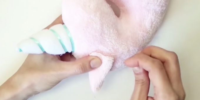 How to make a stuffed toy: sew on the horn and ears