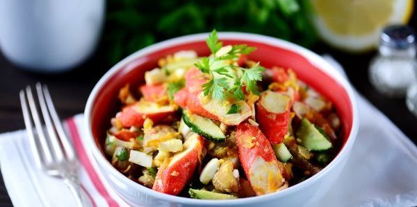 Salad with fried crab sticks, mushrooms, cucumber and eggs