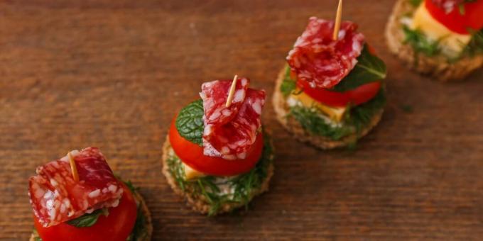 Simple canapes with sausage, cheese and cherry tomatoes