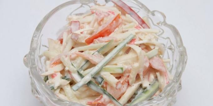 Salad with apple, crab sticks, tomatoes and cucumber