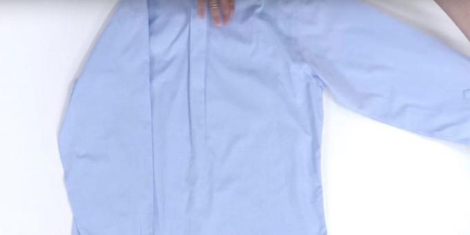 How to fold a shirt: first apply one arm on the edge of the shirt