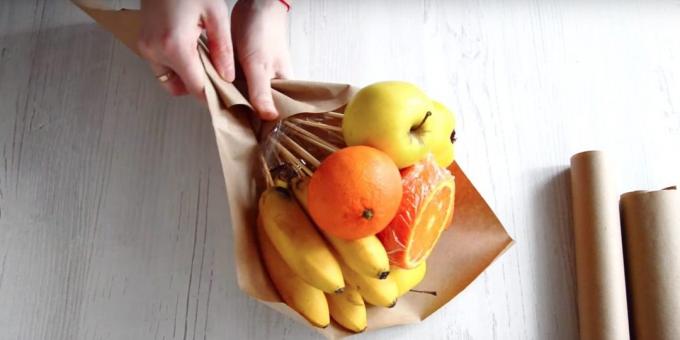 Put a bunch of fruit with your hands diagonally across the paper and wrap the bottom